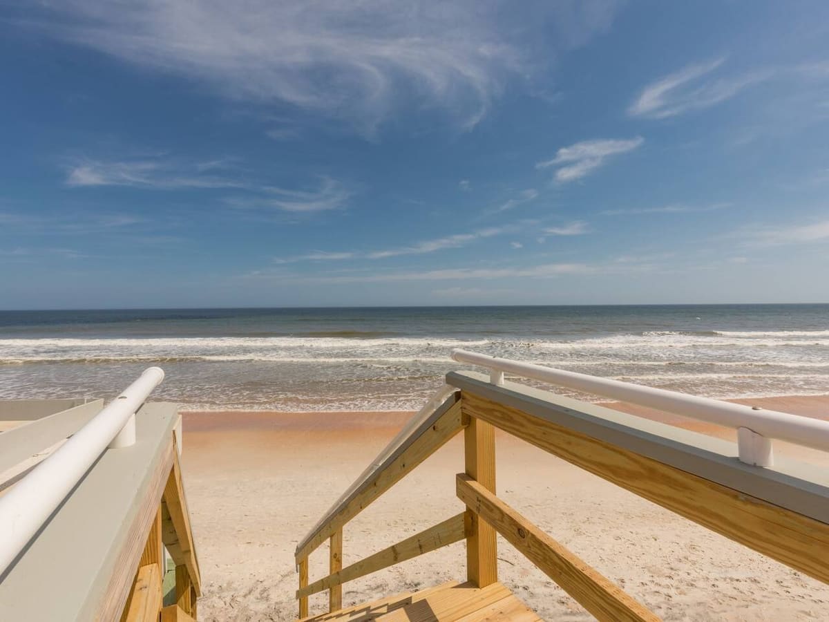 The top of a wooden dune walkover at Vilano Beach, looking down the steps to the sand and the Atlantic surf